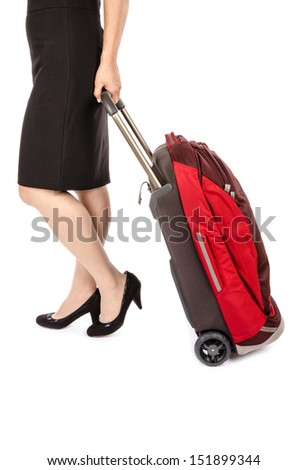 Woman Wearing Black Pencil Skirt and Pumps Pulling a Small Travel Luggage