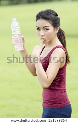 young woman drinking water after exercise