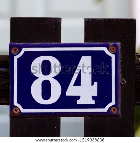  number 84 on a black wooden front gate