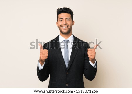 Young handsome businessman man over isolated background giving a thumbs up gesture