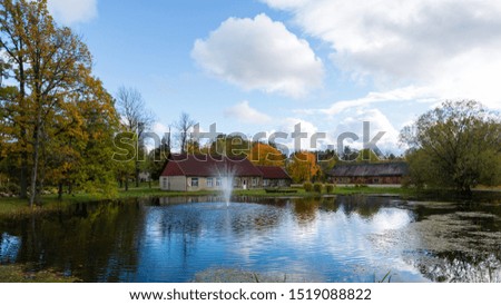 Luznava, Latvia, Autumn landscape with pond and fountain.