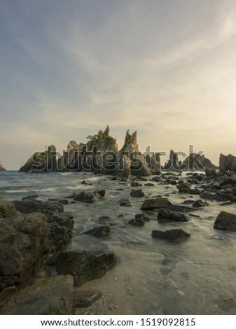 Beautiful view of beach with big coral and sunset sky, batu Hiu coast, Lampung Indonesia