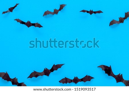 Bats cutout on Halloween frame on blue table top view copy space