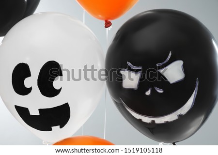 Spooky balloons for Halloween party on light grey background