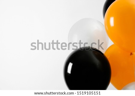 Colorful balloons on light background, space for text. Halloween party