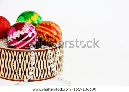 shiny multi-colored Christmas balls toys in a decorative wooden basket for the New Year a holiday