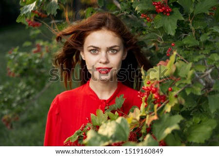 young beautiful woman looking at the camera bright model with berries in the forest
