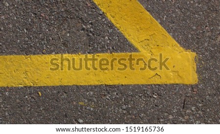 yellow road lines painted on asphalt near a stop a top view