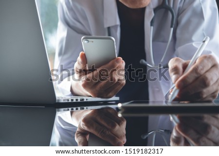 Doctor using digital tablet, mobile smart phone, working on laptop computer in medical workspace office with stethoscope on desk, close up, electronic health record system, medical technology concept