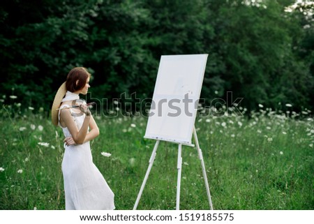 woman model in the forest paints a picture easel