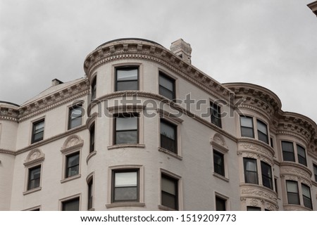 Exterior outside corner of painted brick apartment building featuring beautiful moulding details, horizontal aspect