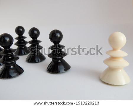 One white chessman standing opposite of a group of black chess p Royalty-Free Stock Photo #1519220213