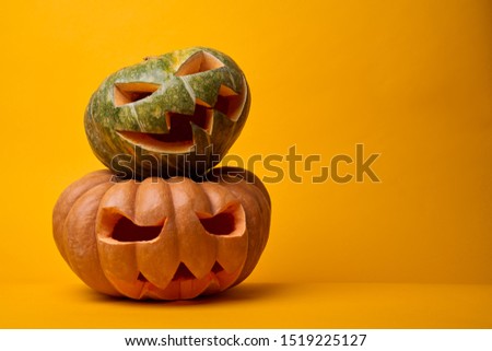 Picture of two halloween pumpkins on empty orange background