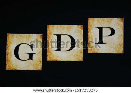 Cards with printed letters G D P (for Gross domestic products) on black background, conceptual image. Rise in GDP, conceptual image. GDP climbing.                              