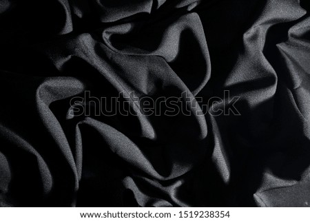 wrinkle black fabric texture, And incident light, Dark background.