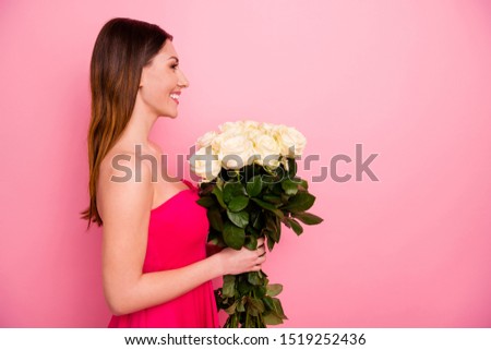 Profile side view portrait of her she nice attractive lovable lovely charming pretty feminine winsome cheerful cheery glad girl holding in hands white roses isolated over pink pastel color background