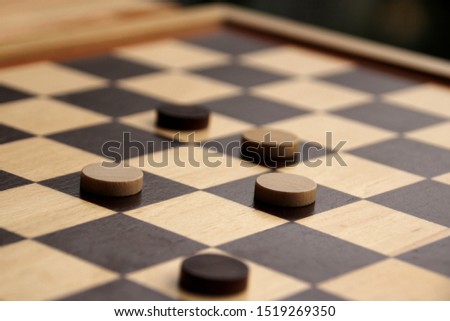 wooden checkers white and dark brown on a chessboard, game concept
