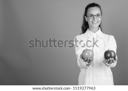 Young beautiful woman doctor against gray background