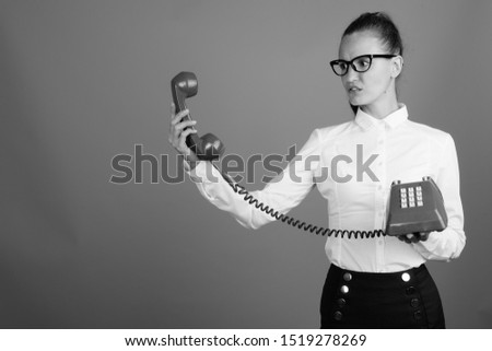 Businesswoman using old phone shot in black and white