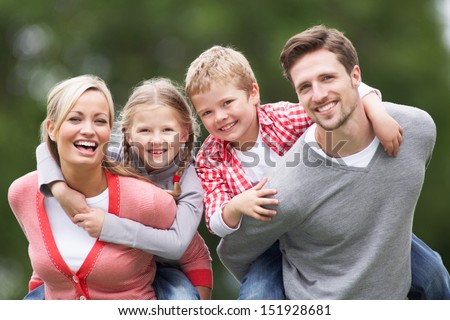 Parents Giving Children Piggybacks In Countryside Royalty-Free Stock Photo #151928681