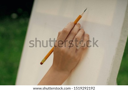 hand on white canvas with pencil