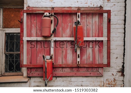 3 Fire extinguishers on the red old wall
