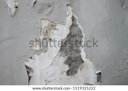 ruined and damaged gray plaster wall with cracks