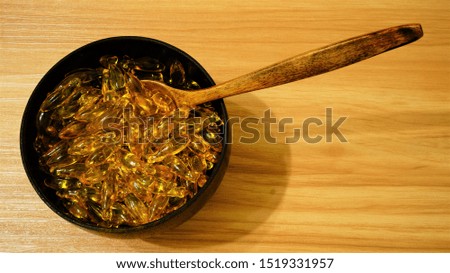 Omega 3 tablets, fish oil in a wooden plate on a wooden table