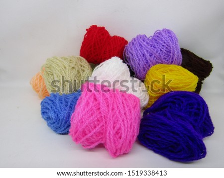 Benang wol rajut or roll knitting wool yarn in various colorful multi colored dye. Made from  natural or synthetic fibers. Detail texture pattern close up view microfiber ball loop waves shape fabric.