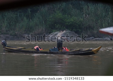 picture is showing a fisherman on a river in the Malaysian jungle
