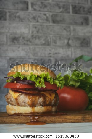 Hamburger or sandwich. Delicious sandwich hamburger with meat, cheese and fresh vegetable. Hamburger or sandwich is the popular fast food for brunch or lunch. Juicy cheeseburger