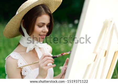 young woman in a beautiful straw hat easel