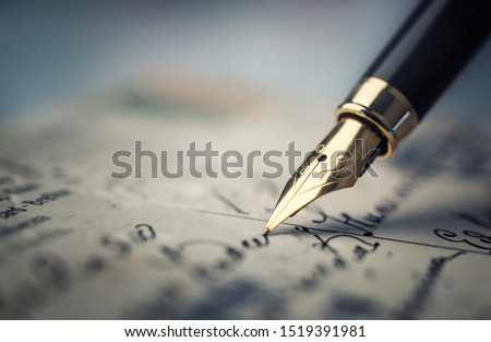 Old fountain pen on an vintage handwritten letter. Conceptual background on history, education, literature topics. Retro style. Royalty-Free Stock Photo #1519391981