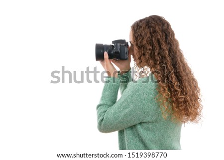 Young Caucasian girl taking pictures with photo camera on isolated white background