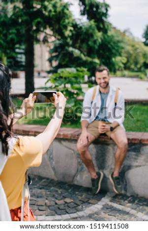 cropped view of girl holding smartphone with blank screen near happy man 