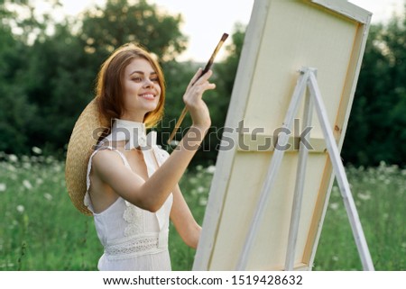 beautiful young happy model woman paints a picture