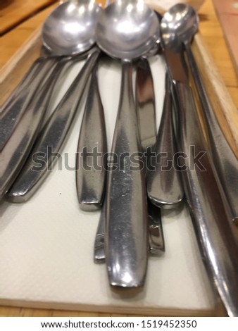 Spoon fork and tissue paper on wooden table in restaurant for customer service. Blurred picture