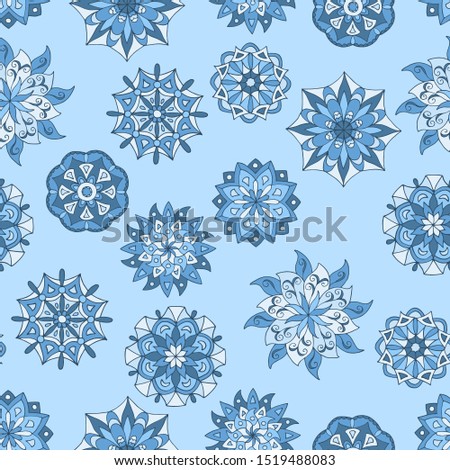 Beautiful seamless pattern with winter mandalas on blue background