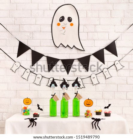 Preparation for kids halloween party with non alcoholic drinks and tasty pumpkin cakes