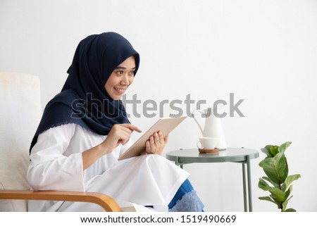 Young Muslim women Students is a creative freelance journalist sit writing to be entrepreneur job concept for hijab girl Islam religion. Asian ethnic joyful internet banking on computer tablet.