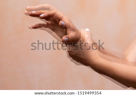A closeup view on the violently shaking hands of a PD sufferer (Parkinson's disease), tremors of the wrist and hand joints are the main symptom of the disorder. Royalty-Free Stock Photo #1519499354