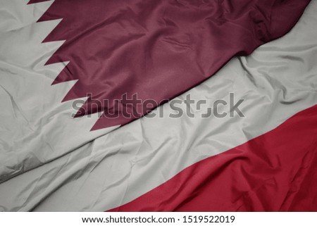 waving colorful flag of poland and national flag of qatar. macro