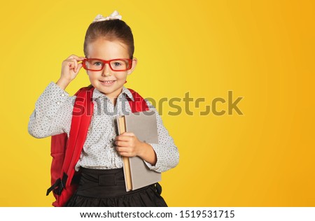 Back To School. Happy Afro Elementary Student Girl Holding Books Smiling At Camera On Yellow Studio Background. Free Space