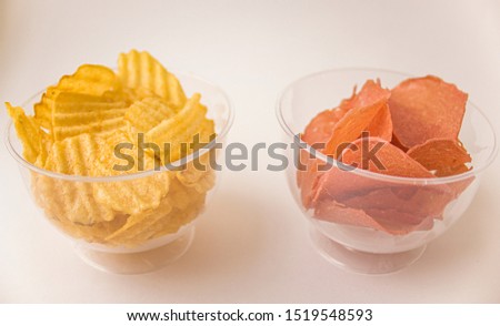 Potato and meat chips in clear glasses. Corrugated potato chips in glass cups. Beer snack.