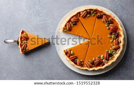 Pumpkin pie on a plate. Grey background. Close up. Top view.