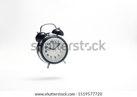 Alarm clock falling on white background.