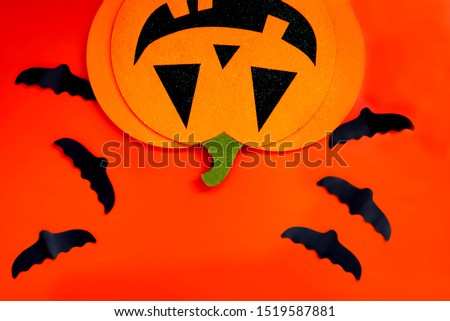 Paper bats, a Jack-o ' - lantern on an orange background. Happy Halloween. Traditions, holidays concept.  Space for your text. Top view. 
