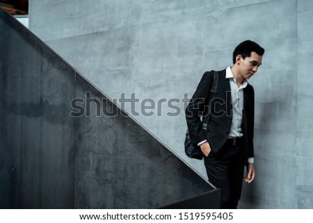 Businessman walking down the stair that has two-tone style like yin-yang. Royalty-Free Stock Photo #1519595405