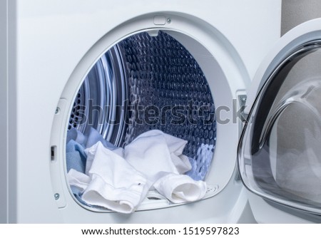 washer and dryer. Clothes hanging from the open machine. Royalty-Free Stock Photo #1519597823