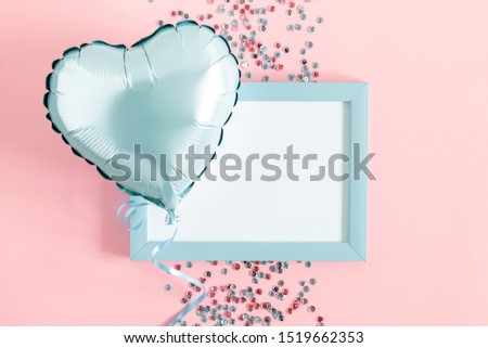 Composition Valentine's Day. Photo frame, light blue ball in shape of heart, confetti on pastel pink background. Valentine day concept, design. Flat lay, top view, copy space